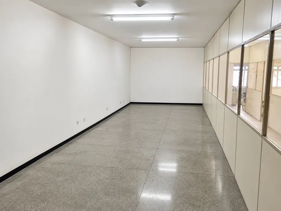 Ambiente amplo com piso claro e divisórias com janelas